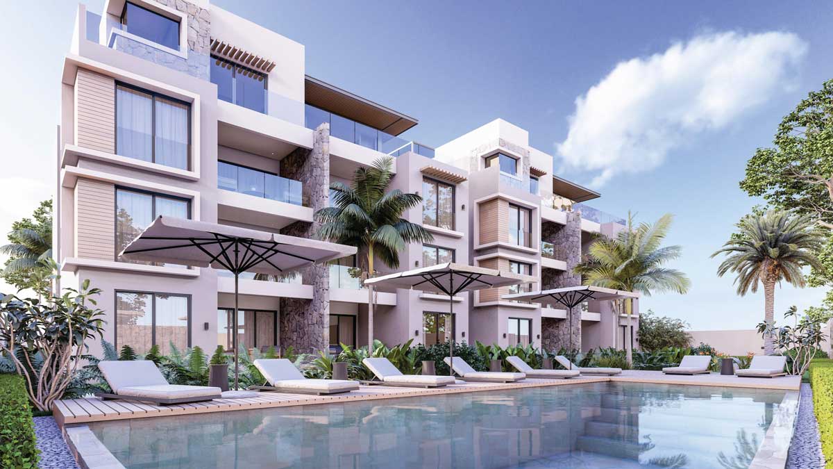 View of the pool and sun loungers surrounded by palm trees at The IVY residence in Cap Malheureux.