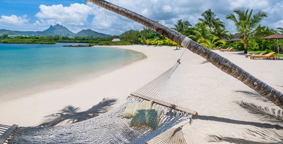 Vue idyllique du Four Seasons Resort Île Maurice avec plage de sable blanc et palmiers